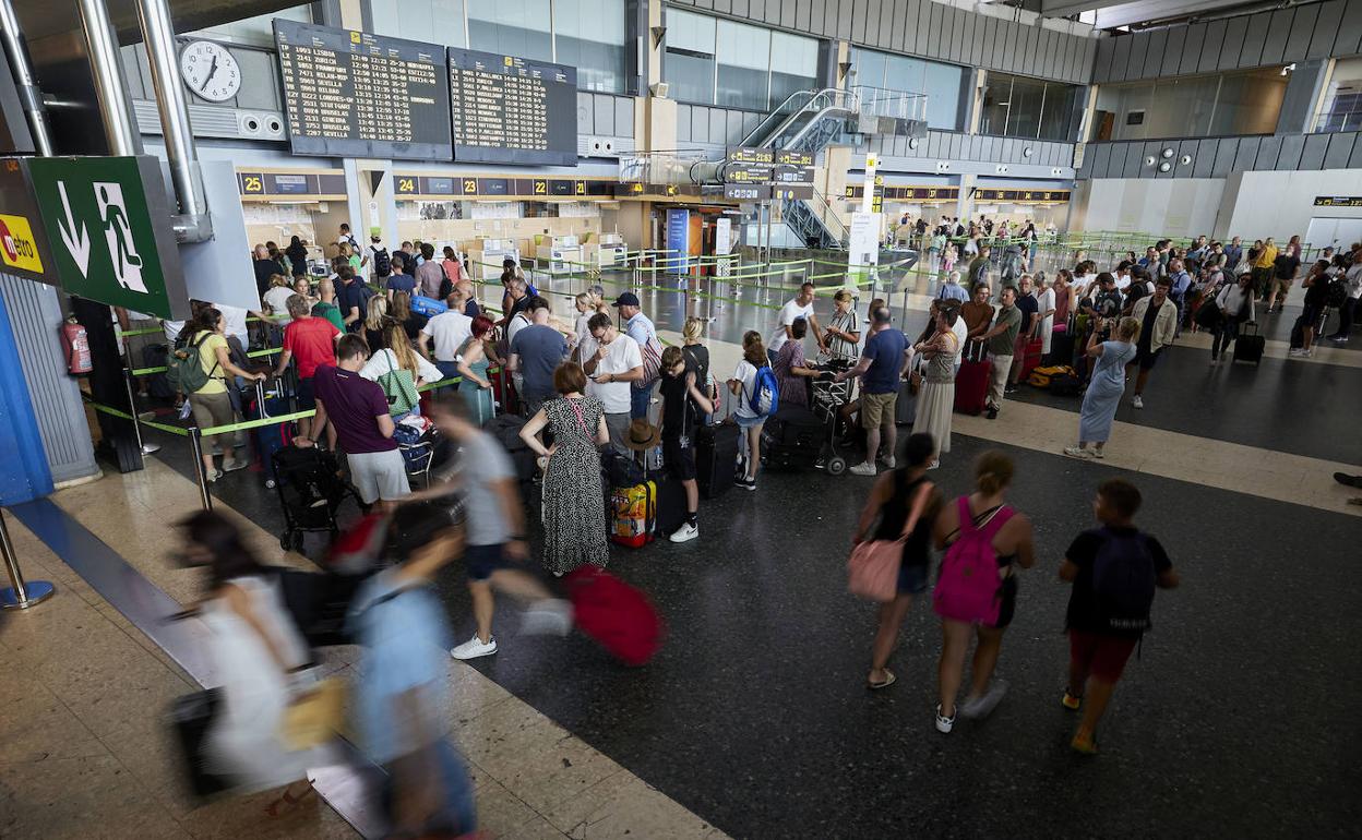 Pasajeros hacen cola para embarcar en los aviones. 