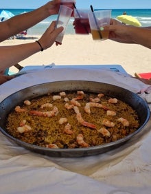 Imagen secundaria 2 - Clientes en Kuk Vermell de Oliva, tanto por la noche como por la tarde, y uno de los arroces que sirven. 