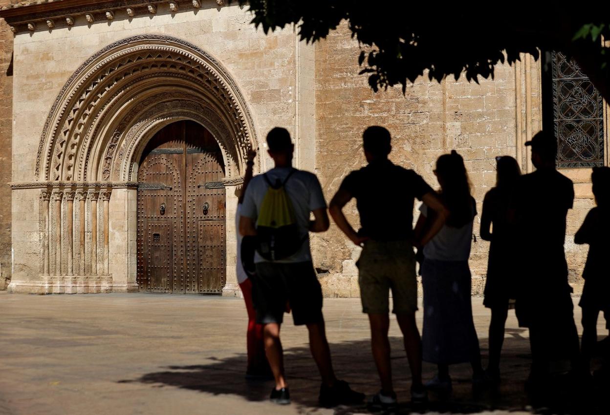 Un grupo de jóvenes se guarece en la sombra junto a la Catedral. lp