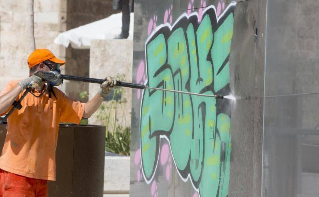 El servicio de limpieza retira la gran pintada de la plaza de la Reina. 