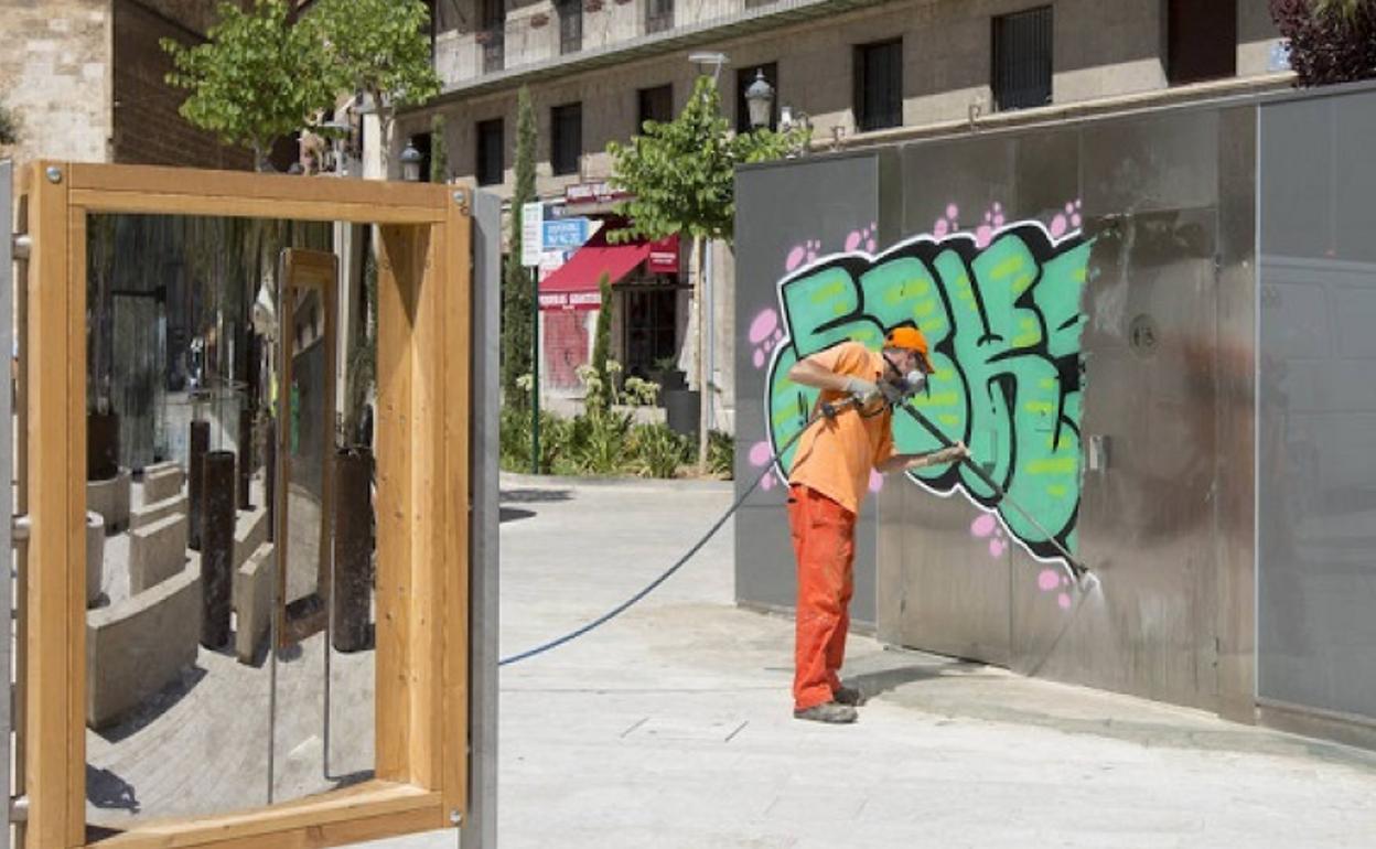 El servicio de limpieza retira la gran pintada de la plaza de la Reina. 