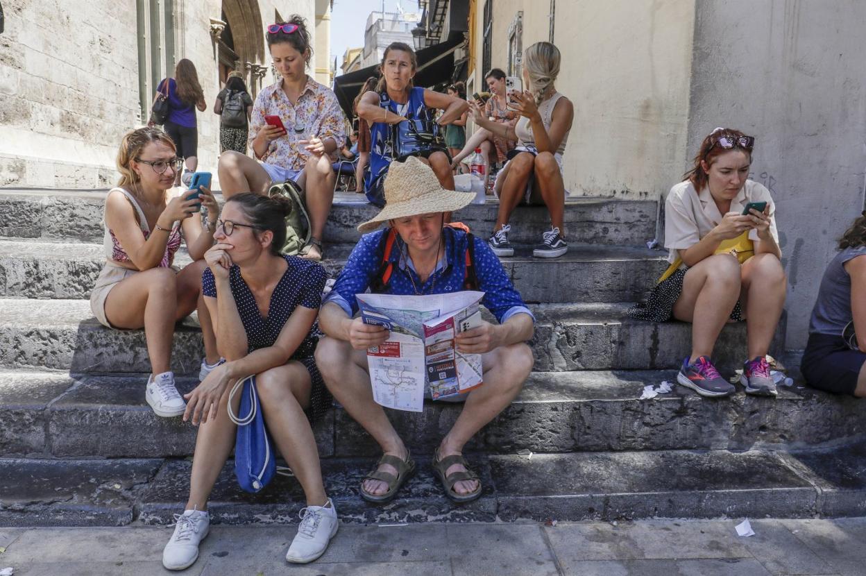 Un grupo de turistas junto a la Lonja este verano.