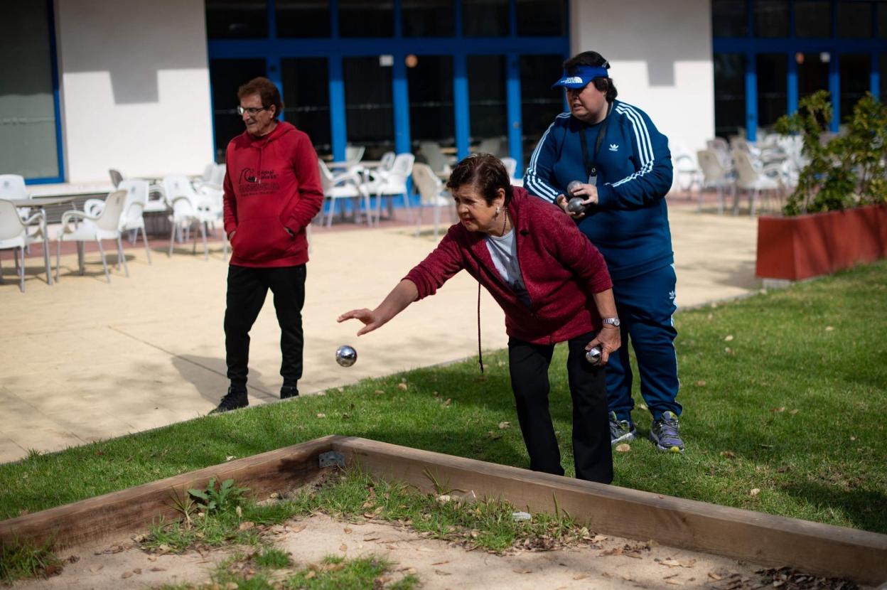 Tres personas mayores juegan a la petanca. afp