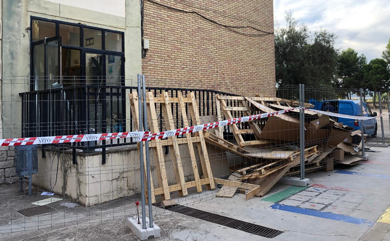 Palés y material de obra junto a una rampa de acceso al patio del María Enríquez de Gandia. 