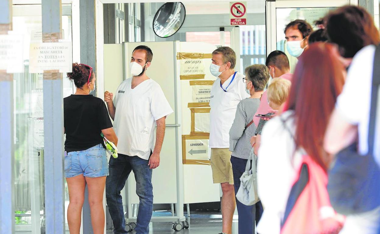 Pacientes hacen cola a las puertas de un centro de salud valenciano.