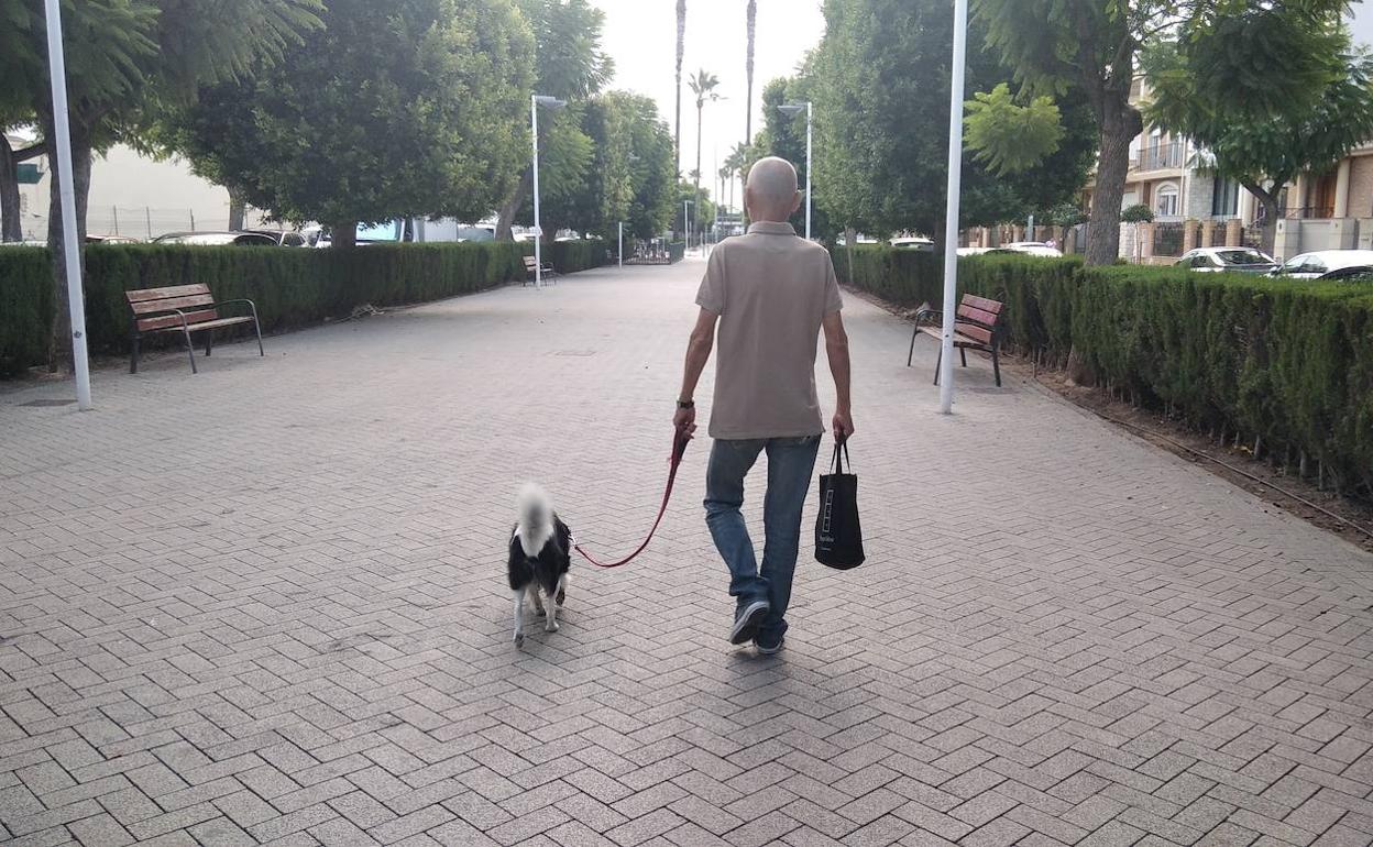 Un hombre pasea con su perro. 