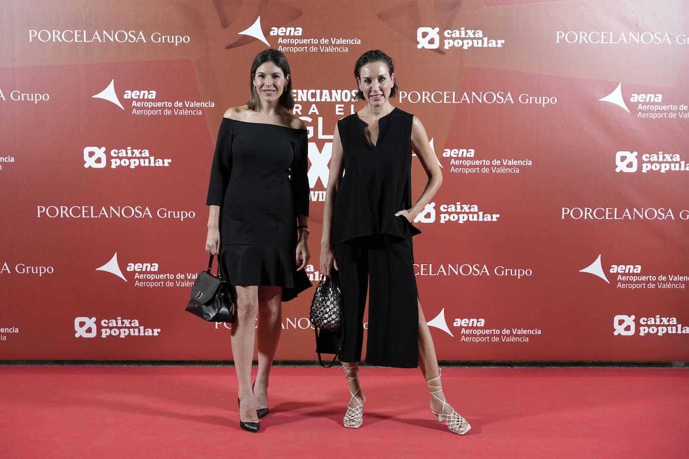 Andrea Marí apostó por un vestido básico de cóctel con escote palabra de honor y volante en el bajo y unos zapatos Louboutine. Bárbara Torrijos lleva un dos piezas de su marca con pantalón crop con aberturas laterales, sandalias de tiras y top sin mangas.