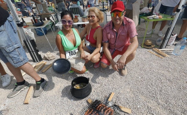 Imagen principal - Las colombianas Alba Cataño y Viviana Martínez con Raúl Sánchez y participantes con la olla y platos. 