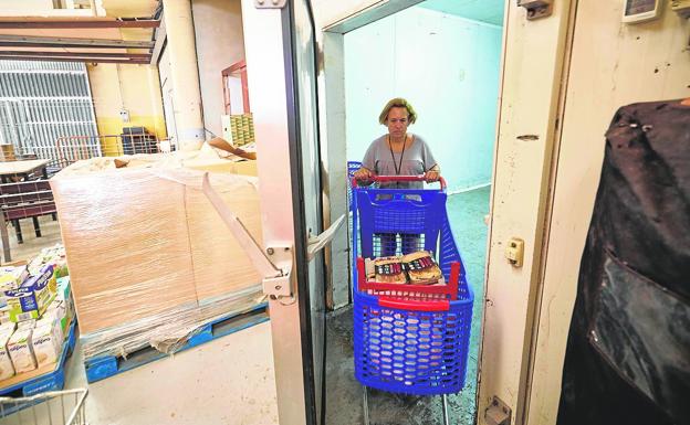 Fresco. Eva saca del refrigerador del Banco de Alimentos un carro con comida congelada para los usuarios. 