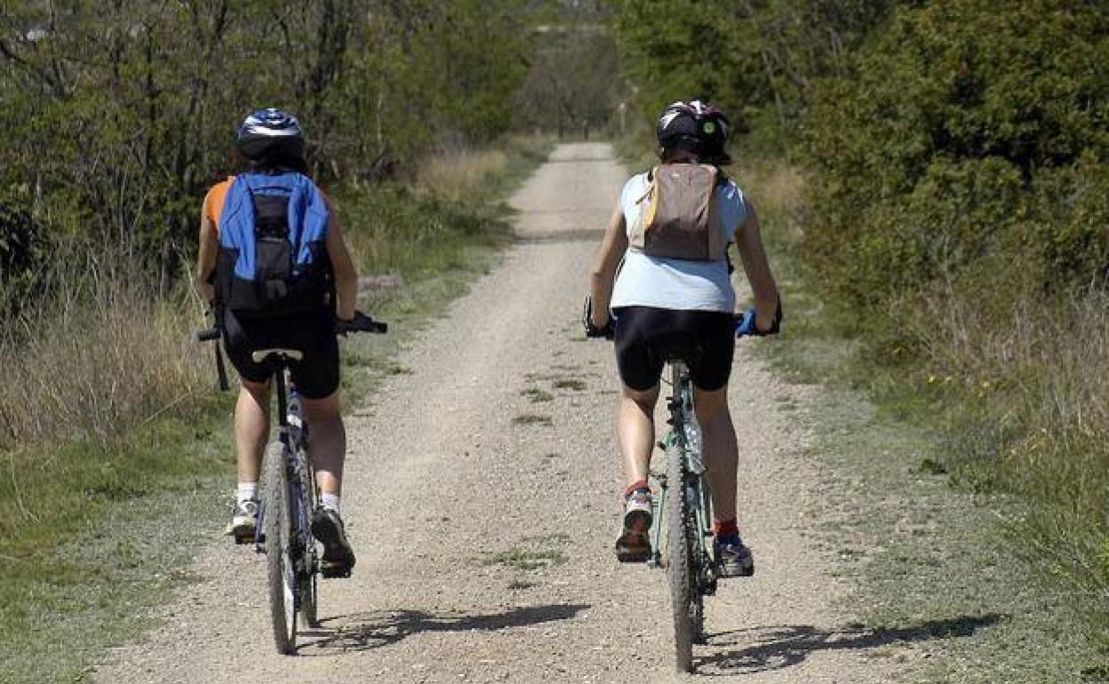 Dos ciclistas por una vía verde. 