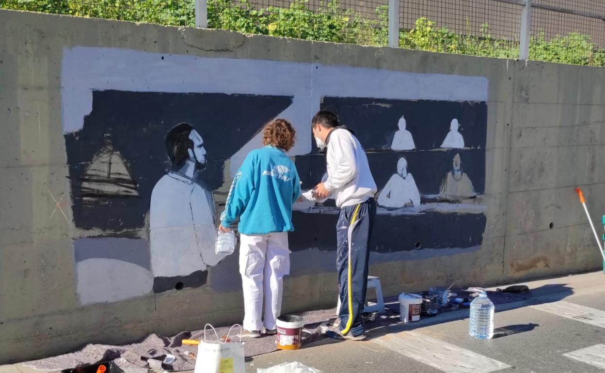 Los artistas durante la creación del mural