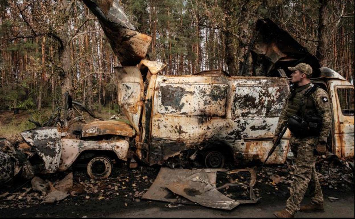 Un soldado ucraniano pasa junto a un convoy militar ruso destrozado en la localidad de Liman, en el frente oriental, donde las tropas de Kiev avanzan a gran velocidad.