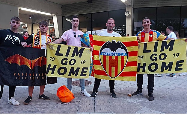 Varios seguidores del Valencia, con pancartas de Lim Go Home junto a la senyera.