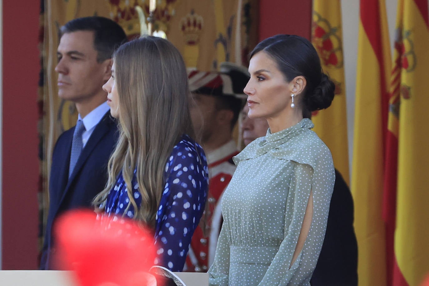 La reina opta por un vestido de gasa en verde con lunares blancos de la firma española Vogana. Se trata del modelo Nanda, de la colección del año 2021, con un precio de 265 euros. En la pieza de silueta fluida y cintura marcada destacaban las originales mangas, con una abertura que dejaba ver discretamente sus torneados brazos y formadan una suerte de capa. Menos discretos son los espectaculares pendientes de perlas australianas que le regaló don Felipe hace más de una década, con los que completó el estilismo.