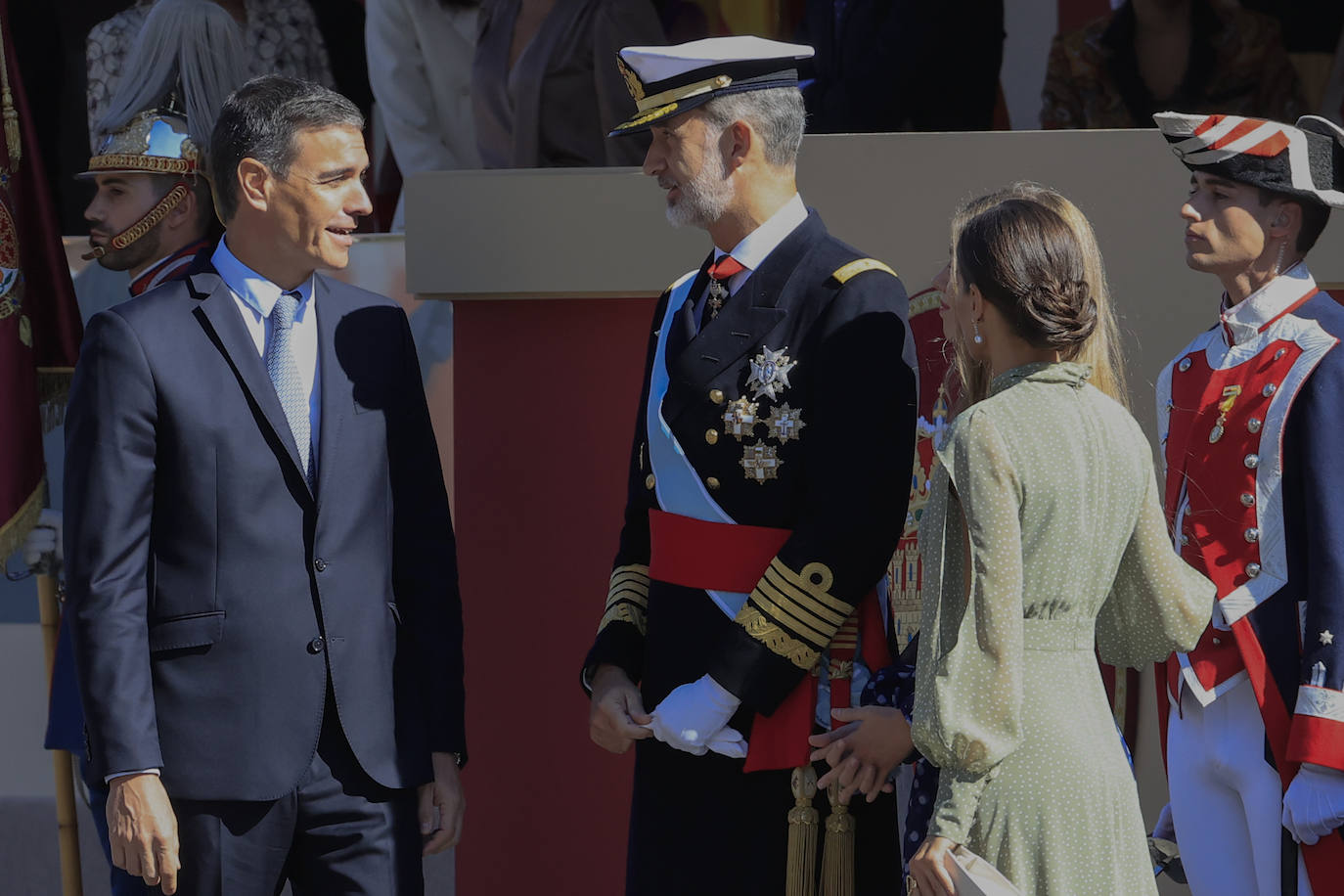 La reina opta por un vestido de gasa en verde con lunares blancos de la firma española Vogana. Se trata del modelo Nanda, de la colección del año 2021, con un precio de 265 euros. En la pieza de silueta fluida y cintura marcada destacaban las originales mangas, con una abertura que dejaba ver discretamente sus torneados brazos y formadan una suerte de capa. Menos discretos son los espectaculares pendientes de perlas australianas que le regaló don Felipe hace más de una década, con los que completó el estilismo.