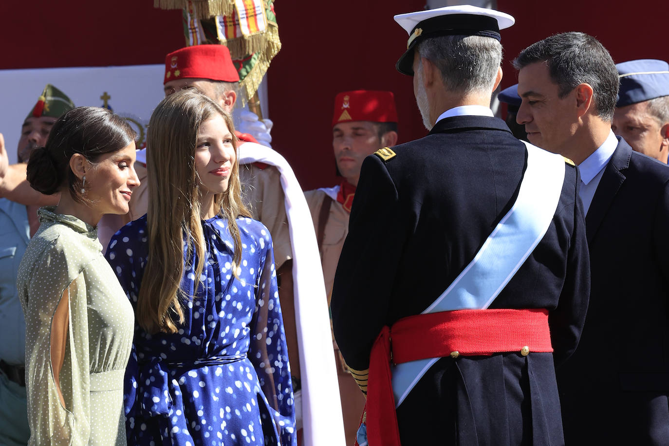 La reina opta por un vestido de gasa en verde con lunares blancos de la firma española Vogana. Se trata del modelo Nanda, de la colección del año 2021, con un precio de 265 euros. En la pieza de silueta fluida y cintura marcada destacaban las originales mangas, con una abertura que dejaba ver discretamente sus torneados brazos y formadan una suerte de capa. Menos discretos son los espectaculares pendientes de perlas australianas que le regaló don Felipe hace más de una década, con los que completó el estilismo.