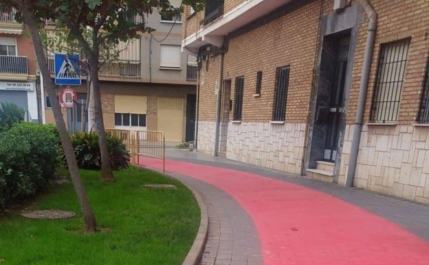 Imagen principal - Otro tramo del carril que discurre junto a la puerta de un patio. 