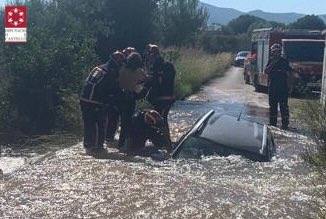 Fotos: Los bomberos rescatan a una mujer atrapada en su coche hundido en un socavón en Onda