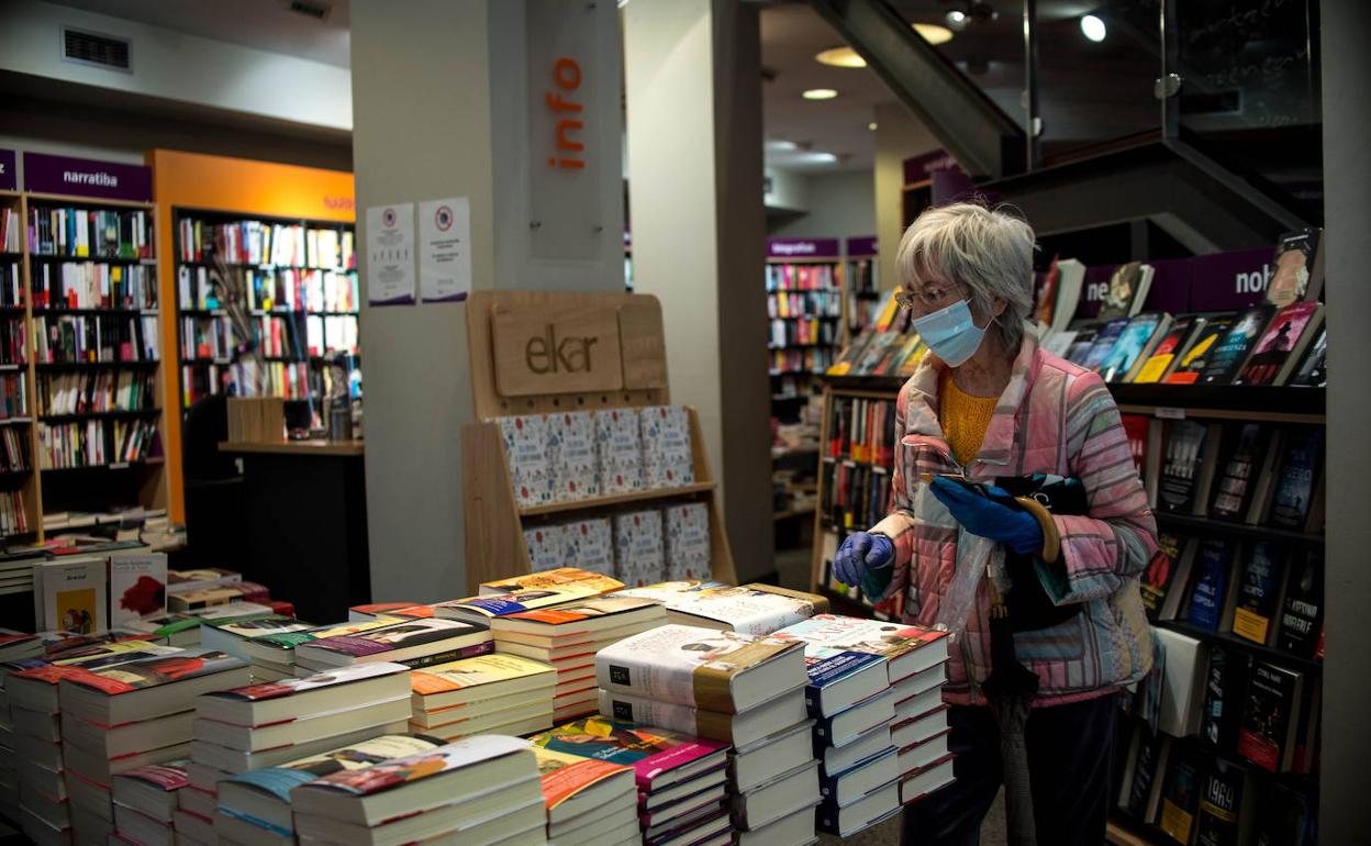 Una mujer busca títulos en una libreria. LP