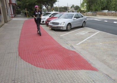 Imagen secundaria 1 - Los vecinos comentan entre ellos y dos patinetes circulan por el carril con obstáculos. 