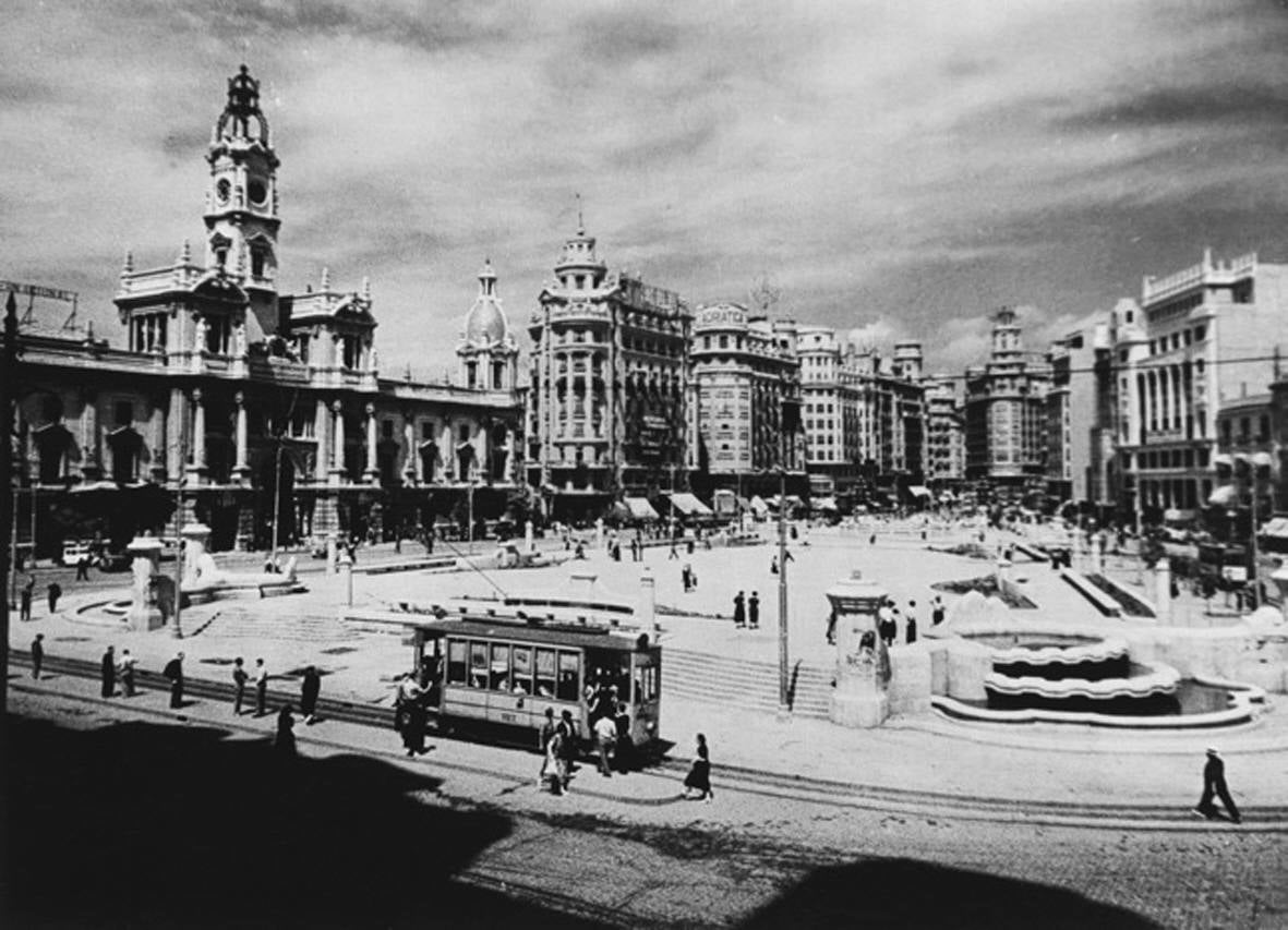 1920. Hace un siglo la plaza aún no era como hoy es, arquitectónicamente hablando. Quioscos en el centro, junto con una estatua central y edificios hoy icónicos aún por construir o en construcción.