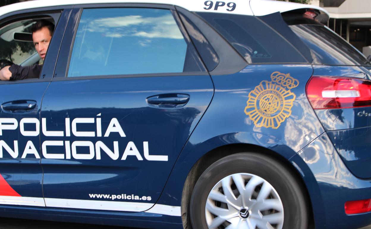 Un agente de la Policía Nacional mira desde la ventanilla de su coche patrulla, en una imagen de archivo. 