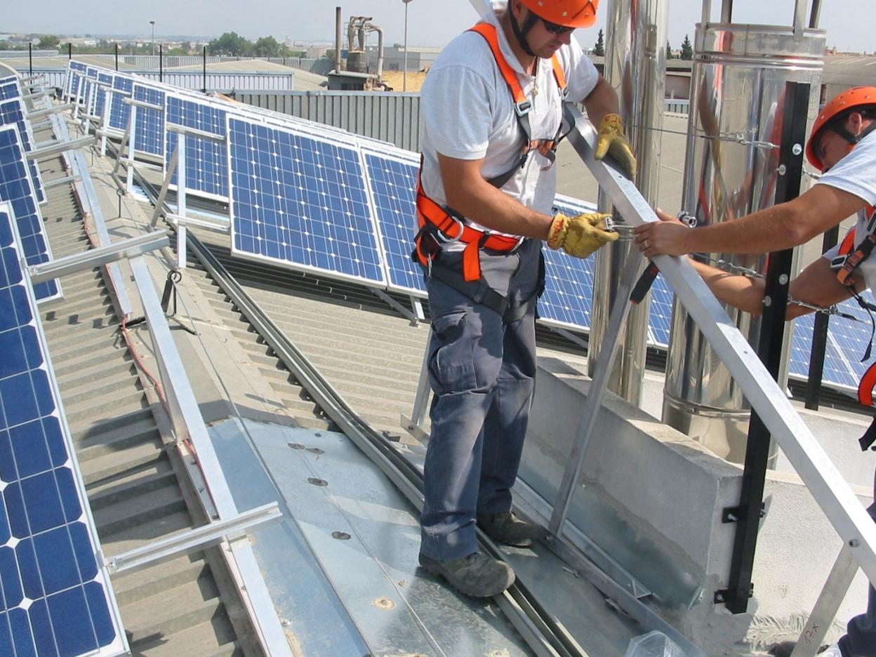 Dos operadores se forman en la instalación de placas fotovoltaicas. 