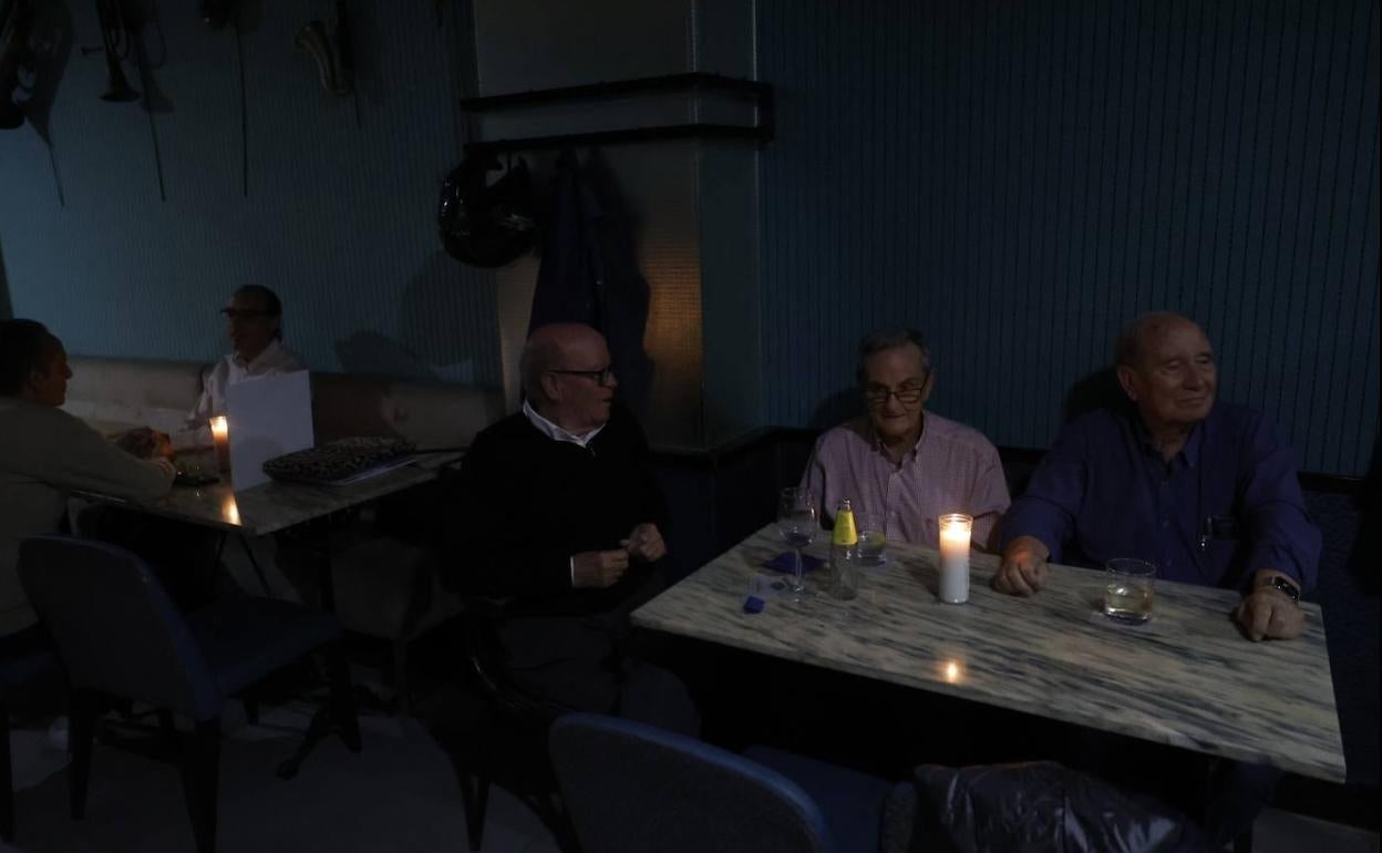 Los clientes de un local en Valencia toman su consumición junto a la luz de una vela. 