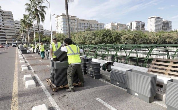 Imagen principal - Reparto de los maceteros, en el puente de las Flores. 