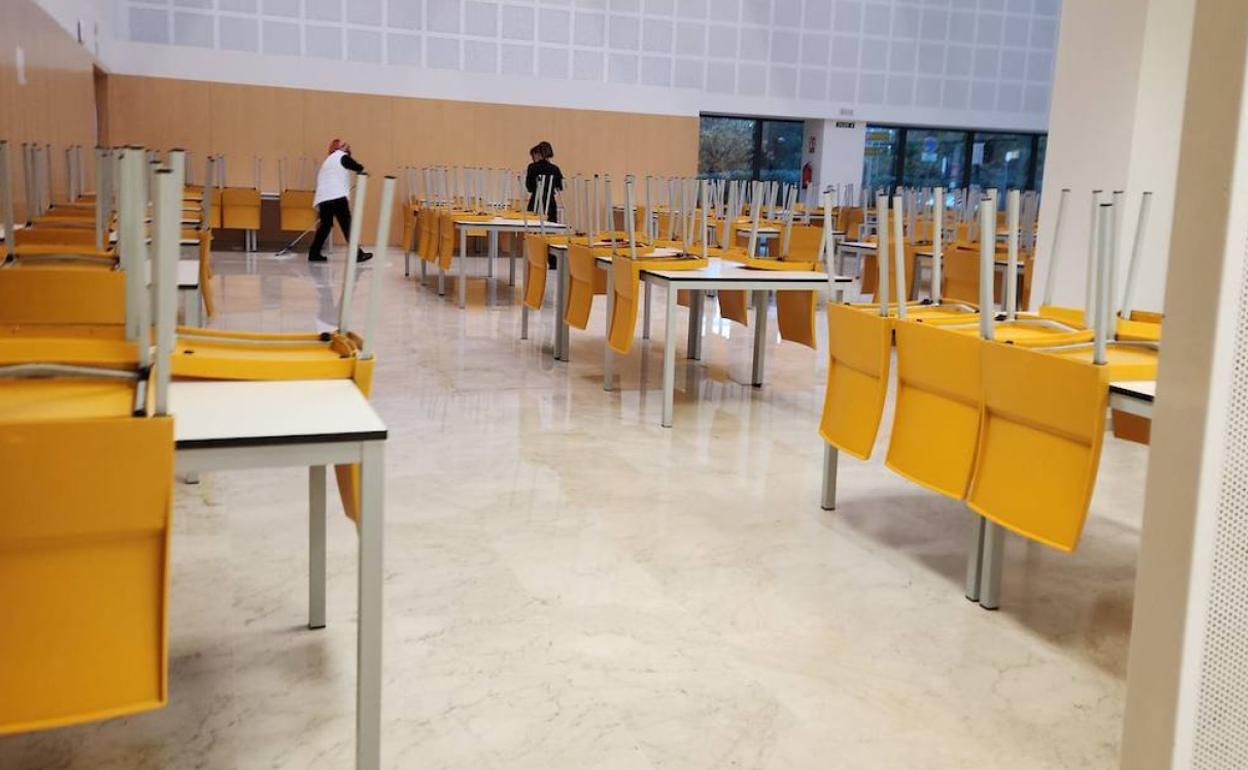 Trabajadores limpiando el agua en una de las cafeterías del hospital La Fe, este viernes.