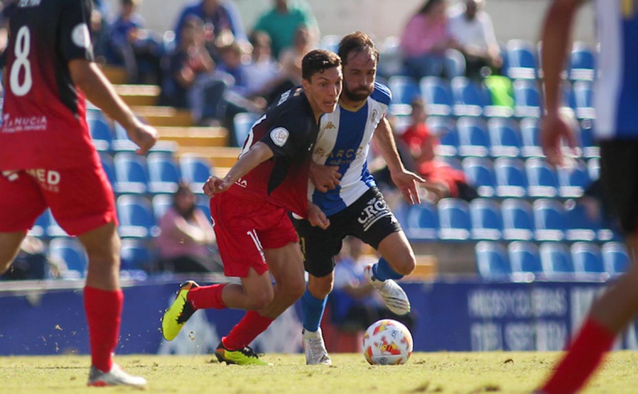 Míchel persigue a Javier Martín en un lance del encuentro de este domingo en el Rico Pérez. 