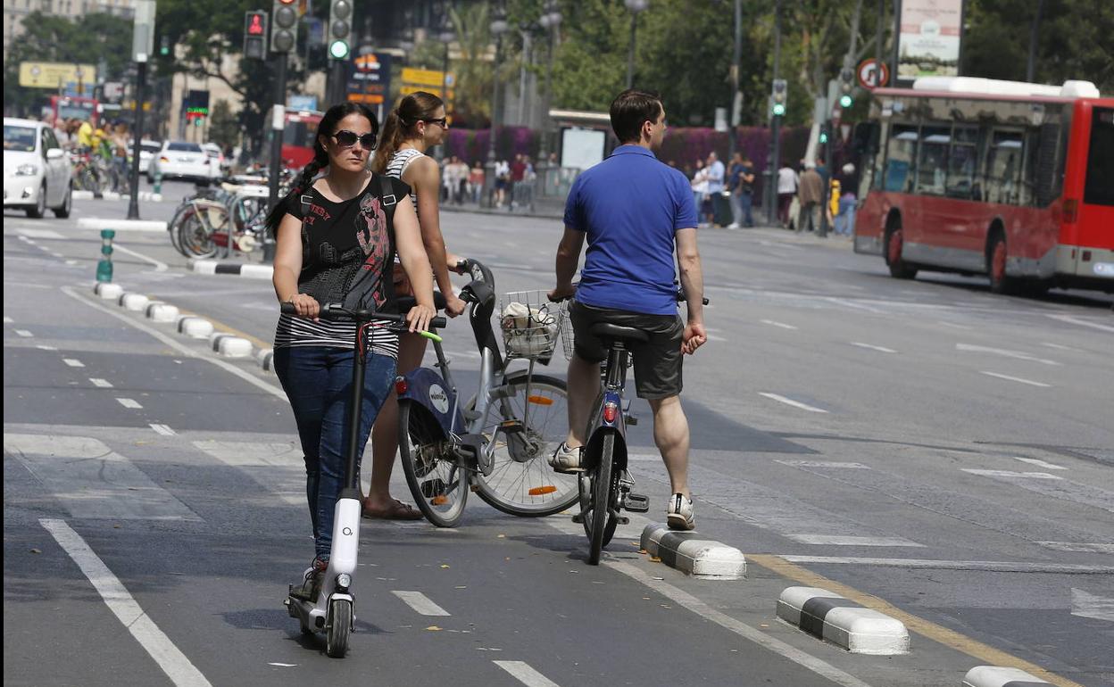 Una usuaria de patinete eléctrico circulando por la ciudad