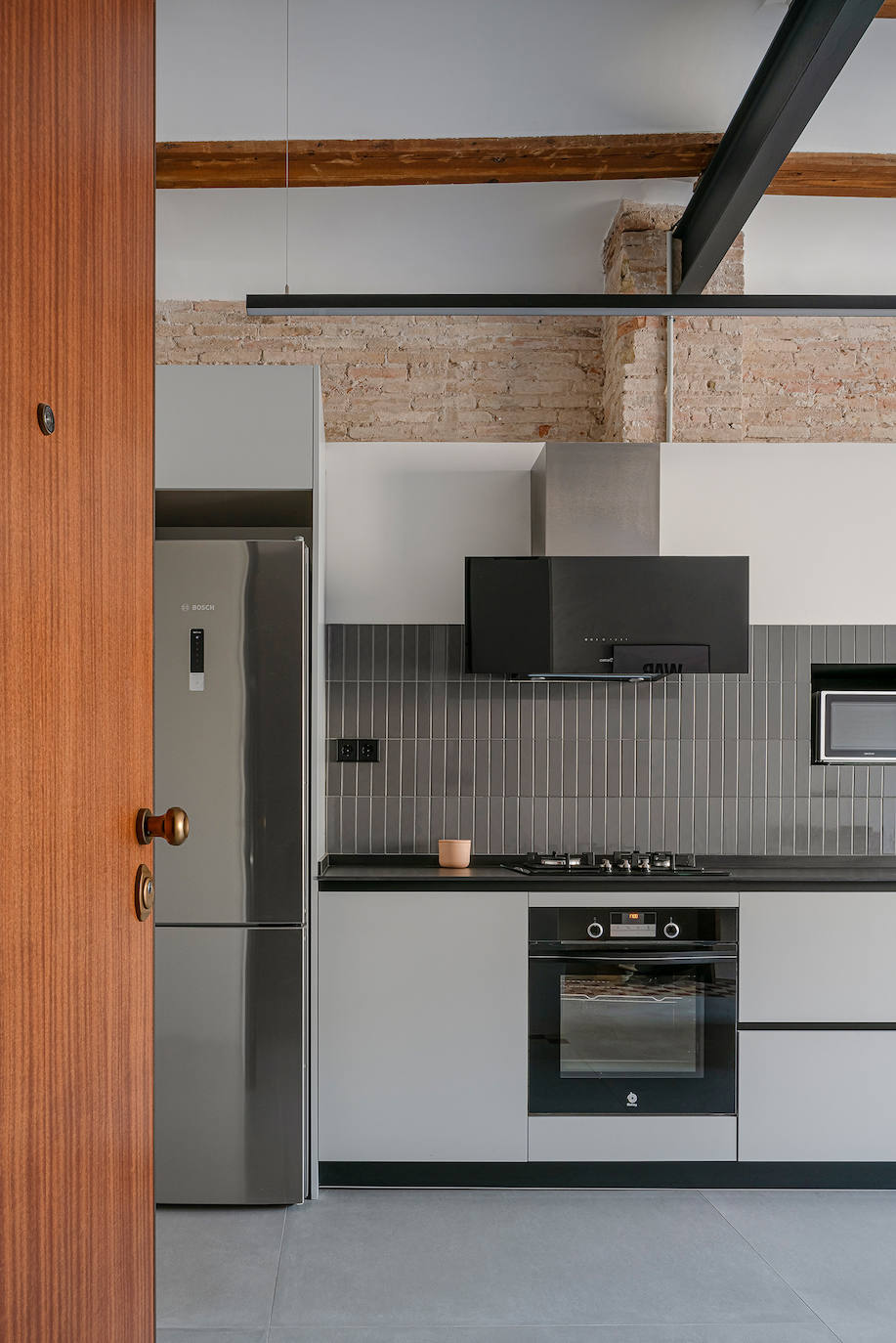 Detalle de la cocina, con la combinación de vigas industriales y vigas de madera.