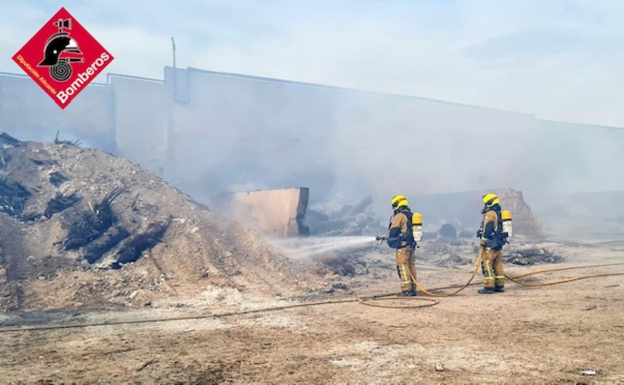 Dos bomberos trabajan en la extinción del incendio. 