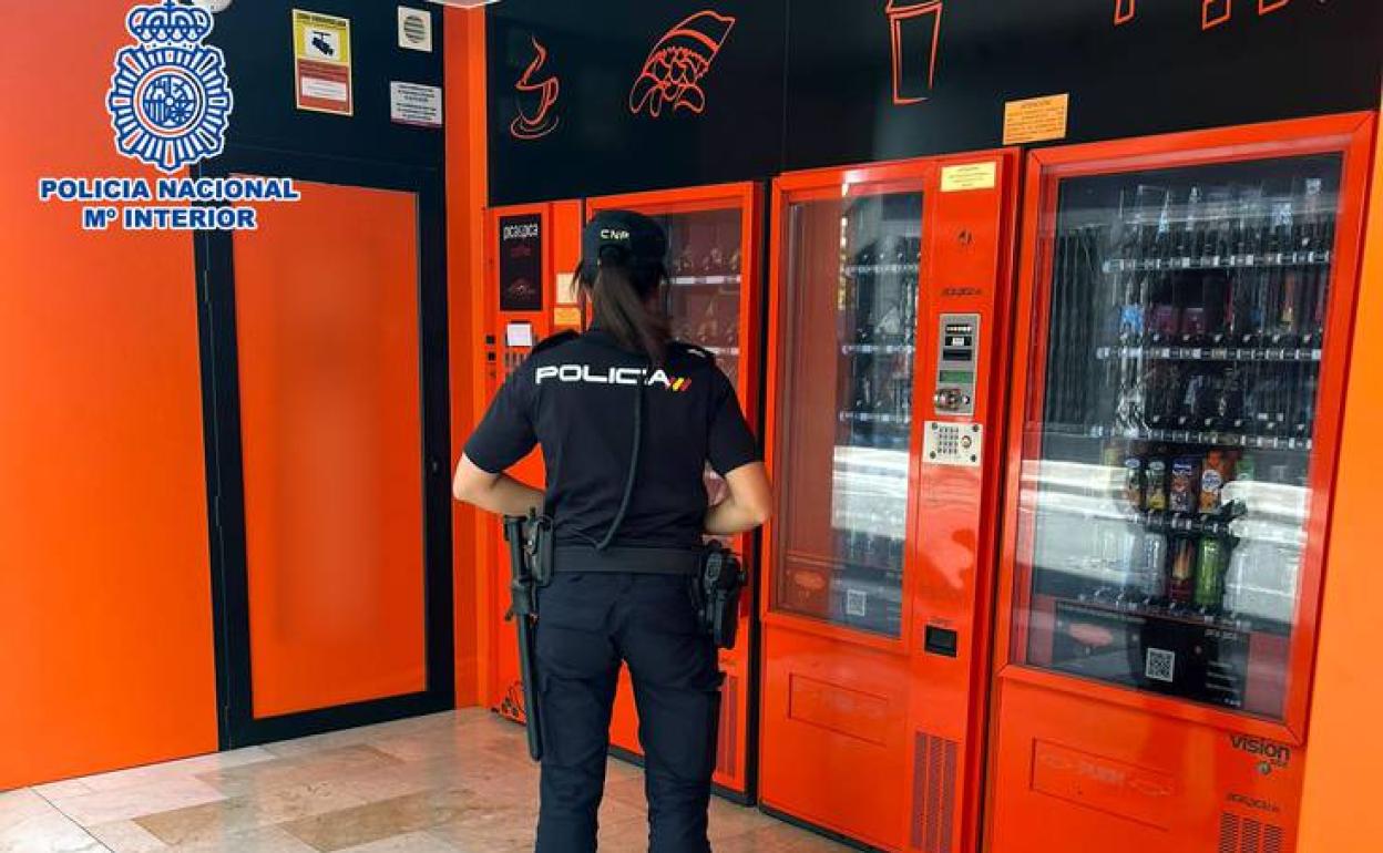 Una agente comprueba una máquina asaltada por el sospechoso. 