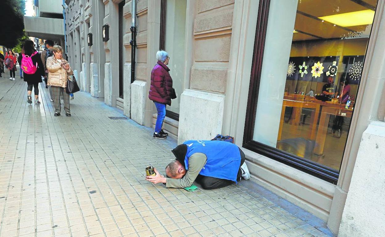 Una persona sin techo pide en la calle Colón, este jueves.