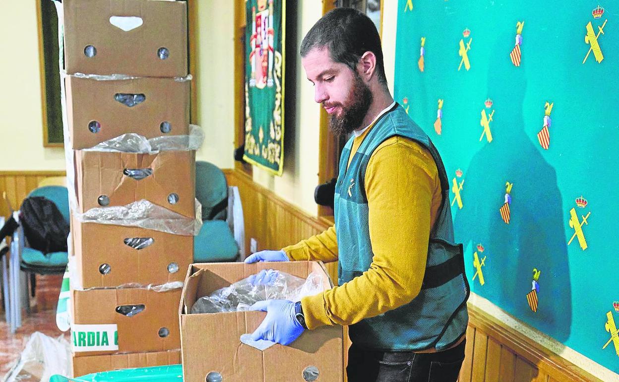 Un guardia civil traslada una de las cajas con paquetes de cocaína. 