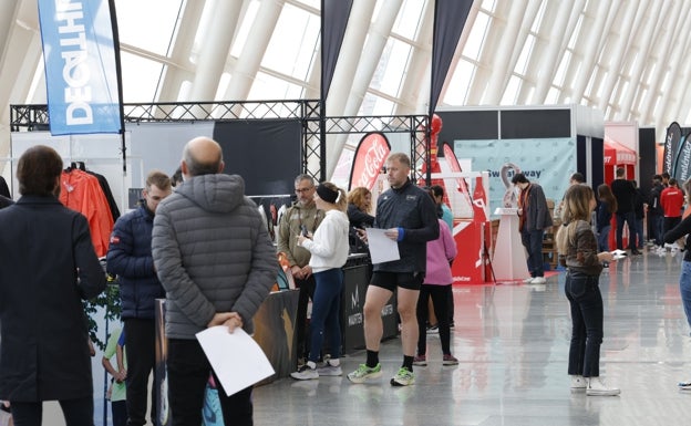 Algunos de los participantes recogen sus dorsales para el Maratón. 