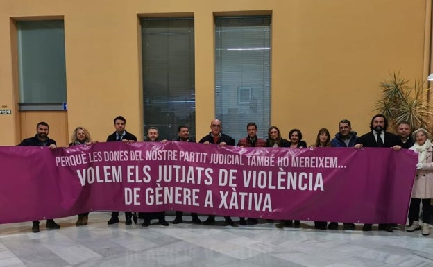 Los abogados y autoridades con la pancarta exigiendo que se mantenga el juzgado de violencia en Xàtiva. 