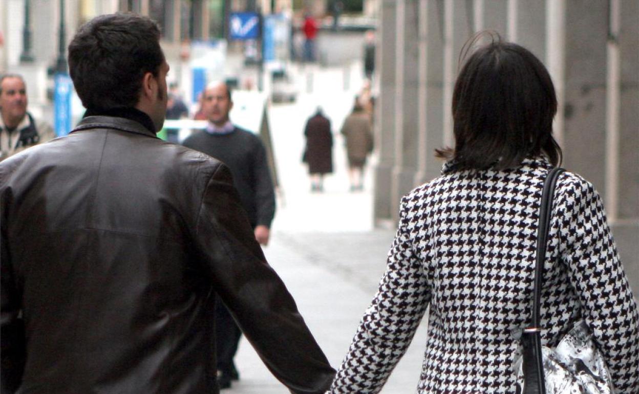 Una pareja pasea de la mano. 