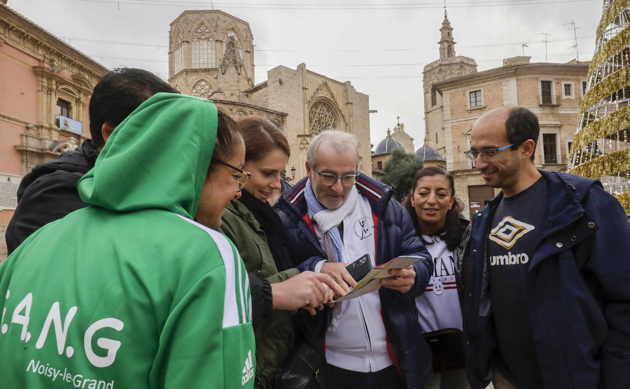 Un grupo de turistas consulta un mapa en la plaza de la Virgen este lunes. 