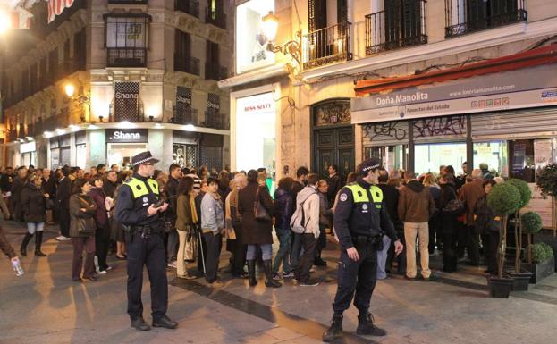 Hasta cuatro horas de cola para comprar un décimo de lotería en Doña Manolita. Imagen de archivo, con vigilancia policial. 