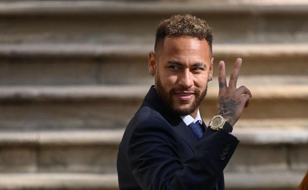 Neymar hace lel gesto de victoria a la salida del juicio en Barcelona. 