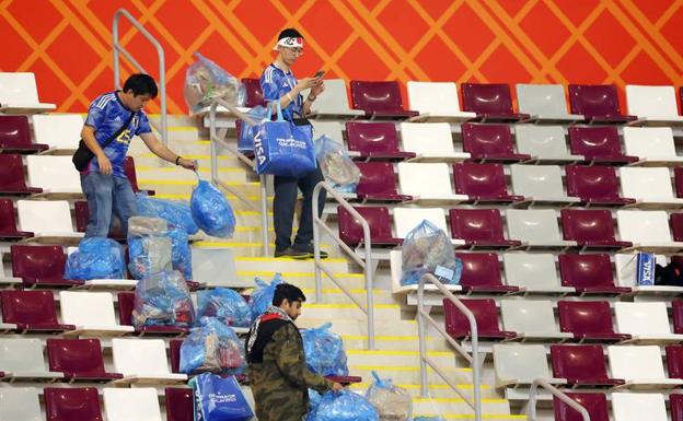 Aficionados japoneses recogen desperdicios tras un partido.