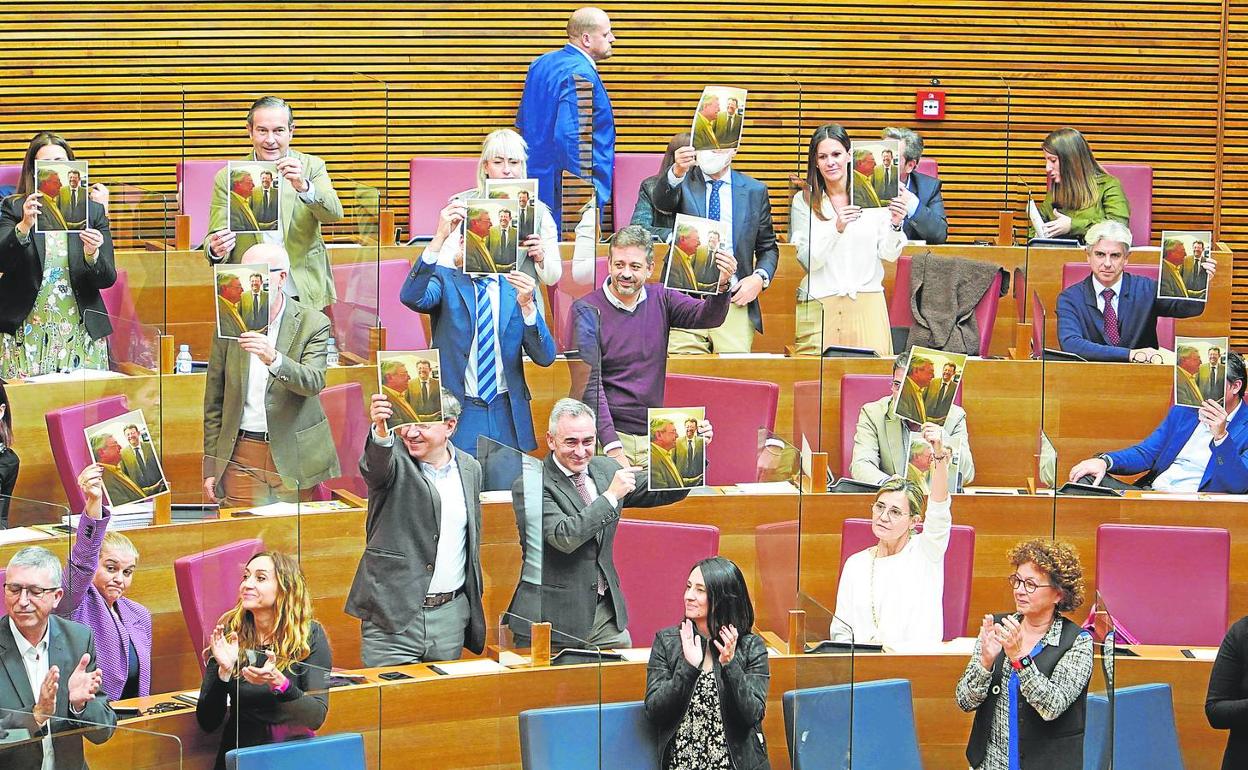 Diputados del PP muestran imágenes de Puig con Cataluña en Les Corts. 