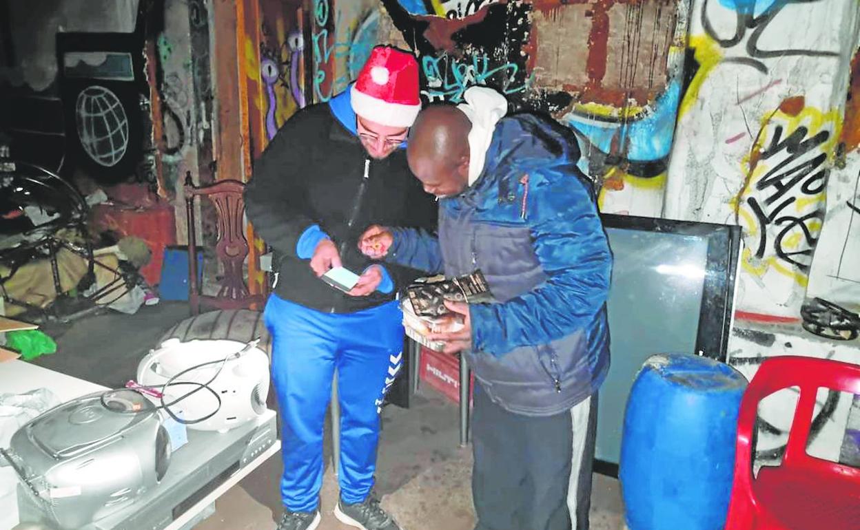 Entrega del menú de Nochebuena a uno de los indigentes de la fábrica abandonada de Benimaclet. 