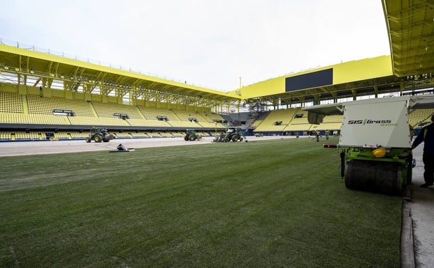 Operarios trabajando con el césped de cara al encuentro ante el Valencia. 