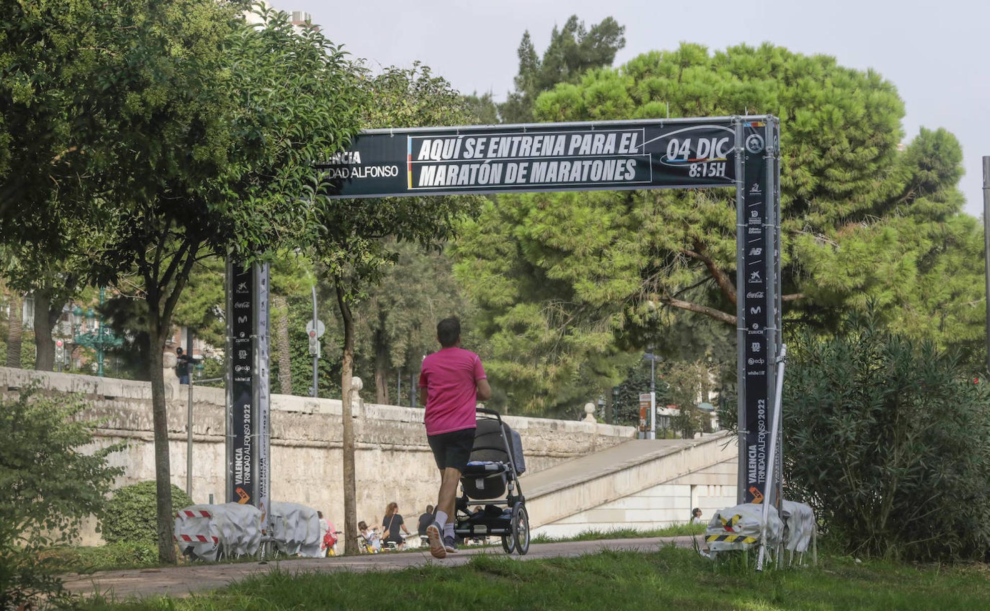 Un bebé es empujado por un corredor en un carrito en el Circuit 5K Jardí del Turia. 