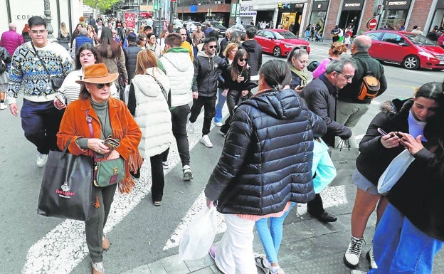 Imagen principal - Calle Colón con gente de compras, y terrazas de la plaza de la Virgen y del Mercado de Colón. 