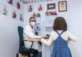 Un pediatra atiende a una niña en su consulta.